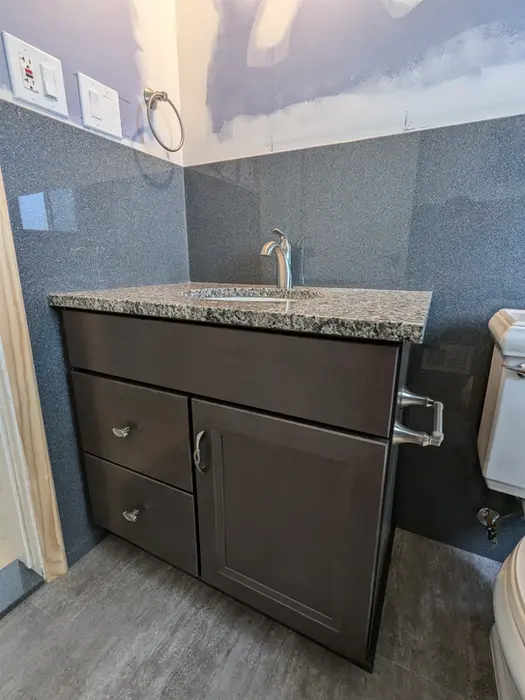 Granite vanity top with cultured marble backsplash and brushed nickel fixtures