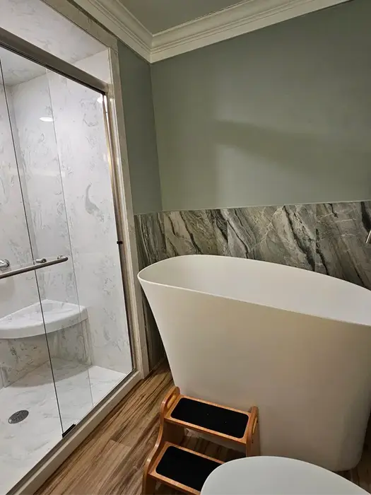 Freestanding white soaking tub in full bathroom remodel