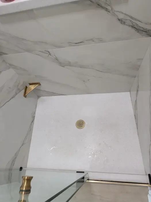 Cultured marble base with porcelain tile shower walls and corner shelving
