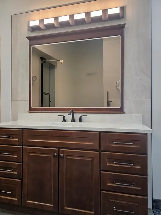 Modern vanity with quartz top and porcelain tile accent wall