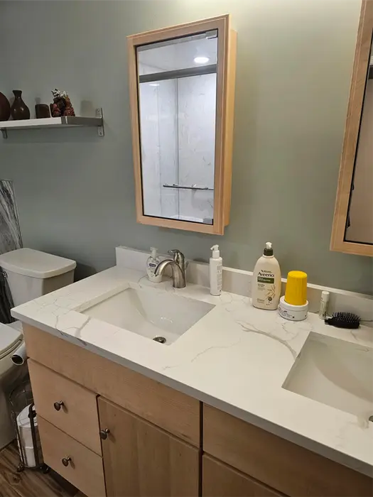 Close-up of quartz vanity top with single bowl and black faucet