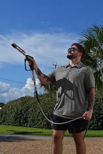 Randy Price with White Sands Pressure Washing spraying a luxury home professionally
