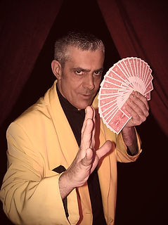 Portrait de l'artiste Tommy Bird, magicien et musicien de l'agence Impulsion, tenant un éventail de cartes.