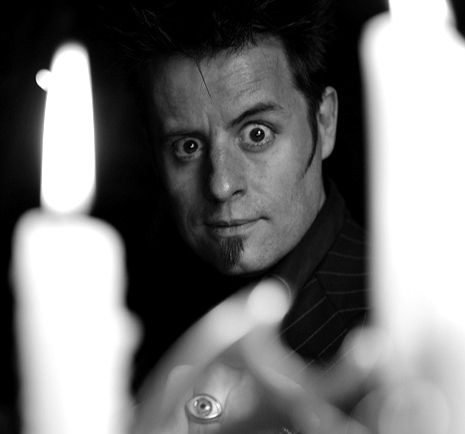 Gros plan en noir et blanc sur le visage expressif d'Erick Fearson filmé derrière la flamme d'une bougie pour l'agence Impulsion