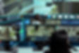 Security camera hub filled with surveillance camera feeds displayed on large screens.