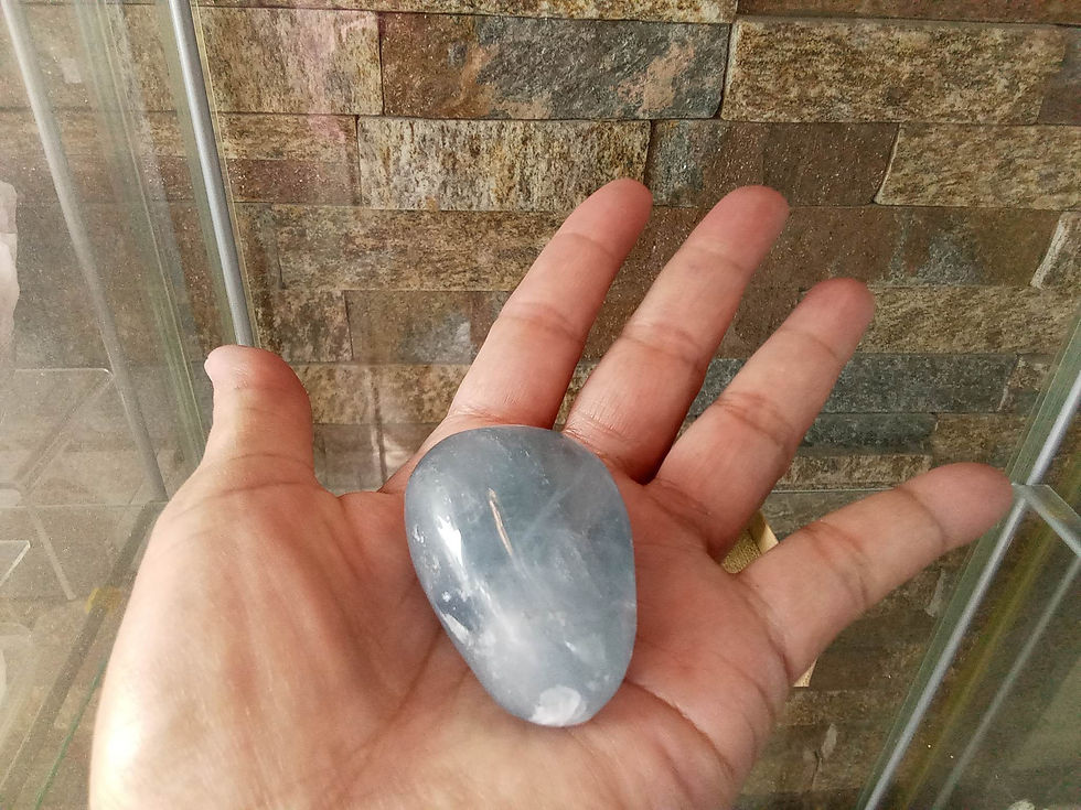 Hand holding light blue tumbled stone