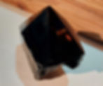 Thumbnail: Black crystal pyramid on wooden surface