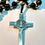 Thumbnail: black rosary beads with a metal cross