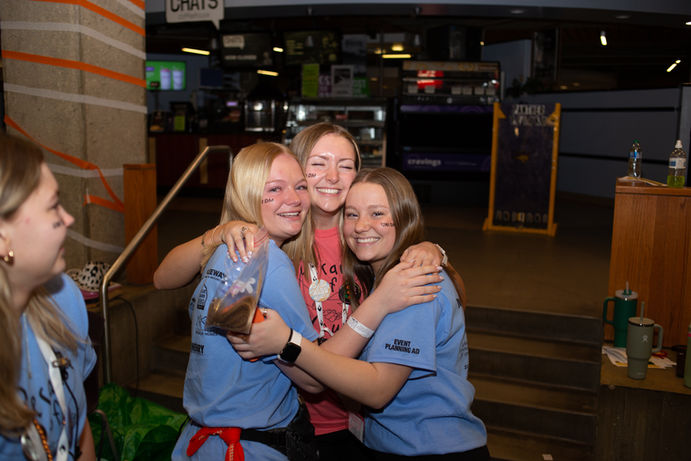 Three girls smiling and hugging
