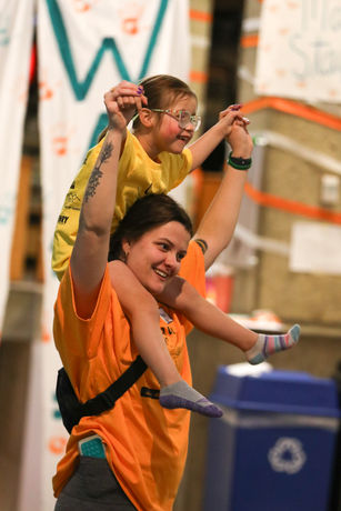 Miracle kiddo sitting on dancer's shoulders