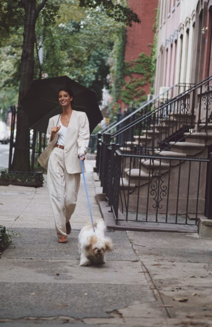 Christy Turlington walking a dog while wearing a crisp Michael Kors suit and moccasins in New York in 1992.