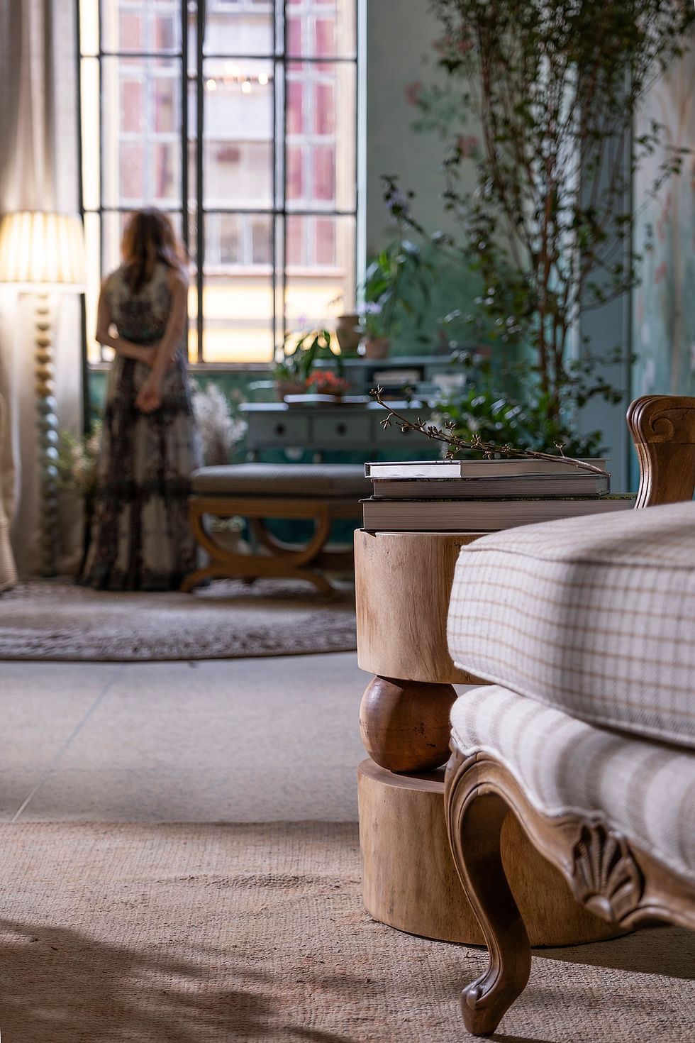 escrivaninha de leitura, poltrona xadrez, plantas, tapete de fibra natural, banco de madeira, livros