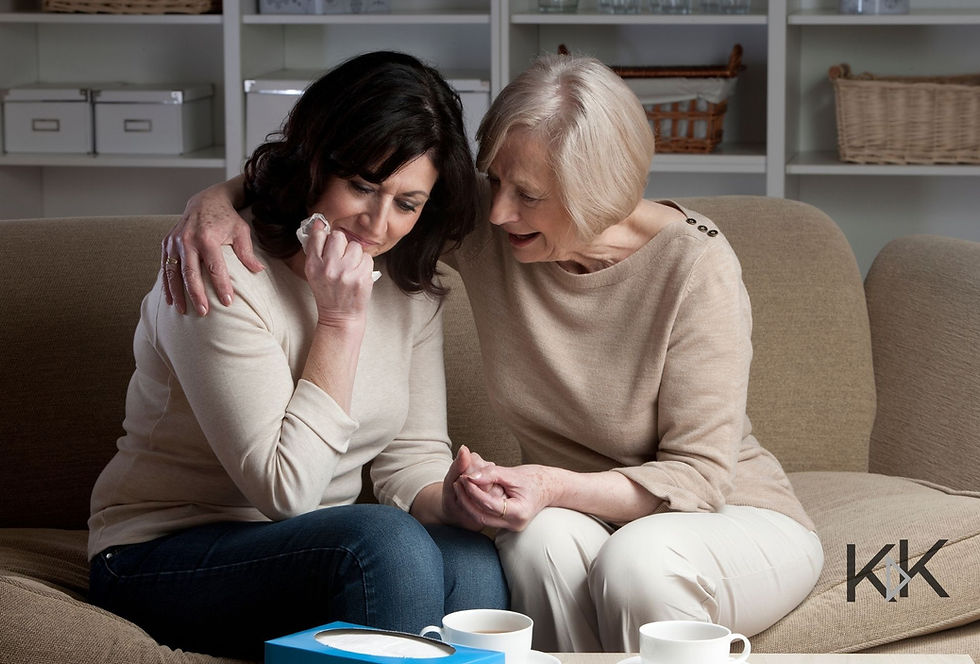 An older lady comforting a younger lady crying on a couch.