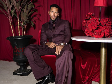 Man wearing a custom burgundy suit by Danny Nguyen Couture in Houston, seated in a luxury red interior.
