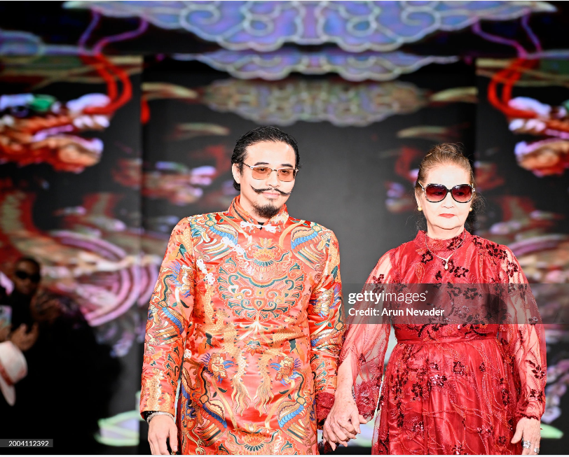 Danny Nguyen and his mother walking the runway together in vibrant custom designs by Houston fashion house Danny Nguyen Couture, celebrating the family legacy behind the brand.