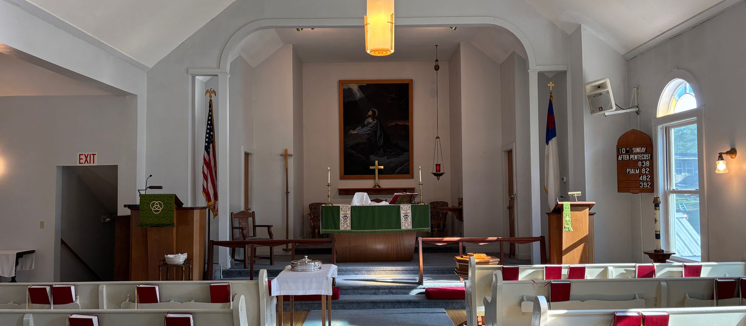 Interior view of a church with rows of pews and an altar visible.