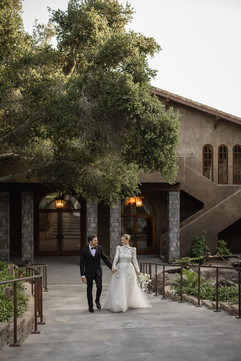 Newlyweds walking through the grounds of Villa Loriana estate wedding venue in San Luis Obispo.
