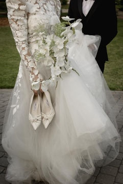 Wedding detail photo at Villa Loriana featuring bridal shoes and cascading orchid bouquet.