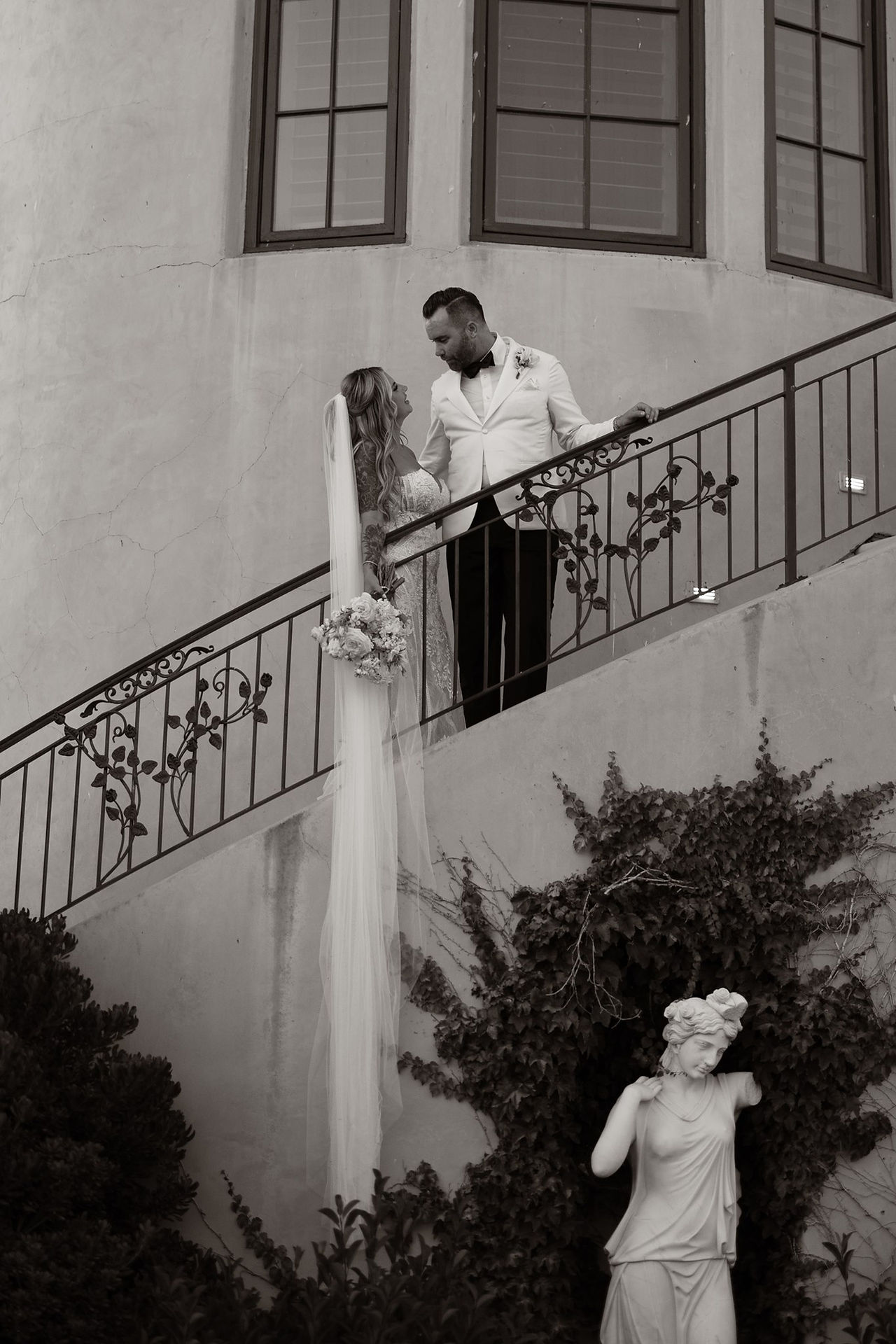 Romantic black and white portrait of a bride and groom on the Villa San Juliette staircase overlooking the estate gardens in Paso Robles wine country.