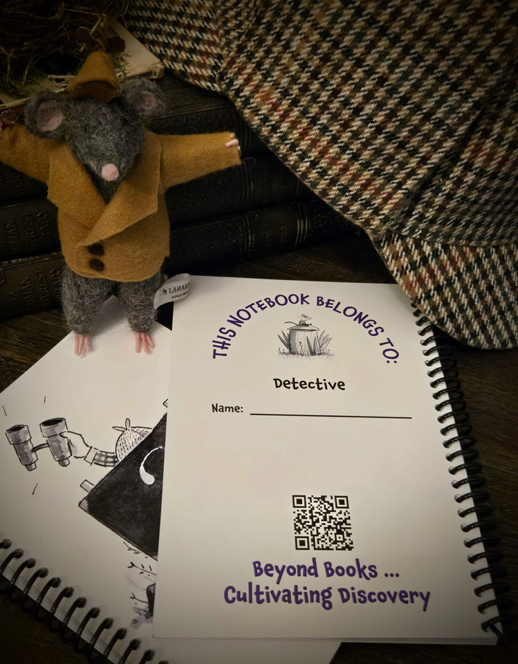 Back cover of notebook with a needle-felted Detective Flint, books, and a detective hat in the background.