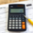tax forms like IRS individual tax return form, a calculator and a pen.jpg