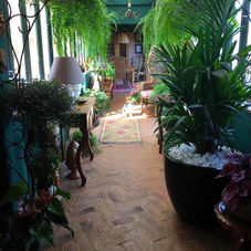 Jardim de inverno com piso de placas de tijolinho rústico de cerâmica na cor marrom, destacando acabamento natural e textura artesanal