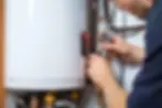 ProTeam plumbing technician adjusting the pressure and temperature relief valve on a resid