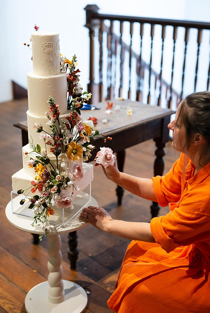 Placing sugar flowers on an Autumnal cake