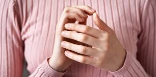 Close-up view of fingertips gently tapping on the side of the hand