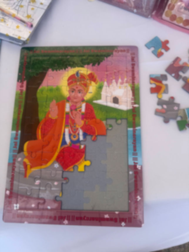Half-finished Swaminarayan Bhagwan jigsaw puzzle showing bright, colourful artwork coming together piece by piece