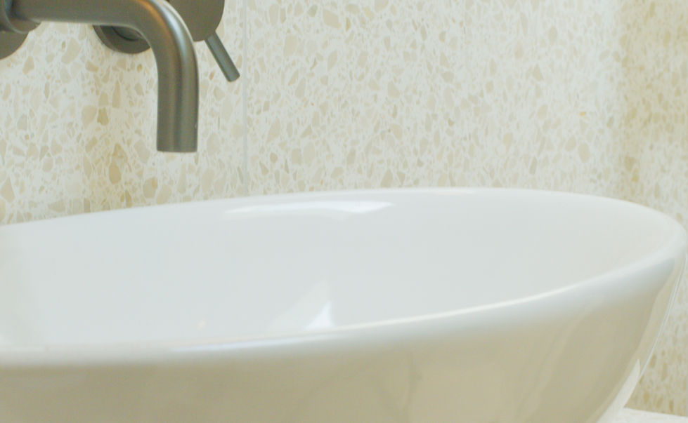 Modern sink and wall-mounted tap inside bathroom of bespoke London garden room.