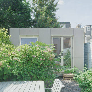 Light-filled Walthamstow, East London garden office lounge with Viroc panel facade, radiata pine interior, built-in desk and sofa