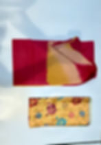 Folded Devika yellow-red cotton suit fabric pieces.