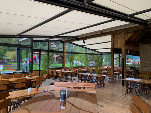 3-teilige Laimer Großflächenmarkise mit rundum Verglasung und Slide Ganzglas-Schiebewänden als Windschutz auf der Terrasse des Restaurants Flachauer Gutshof in Flachau