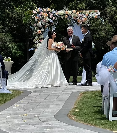Bride and groom exchanging vows during an elegant outdoor garden wedding ceremony at The Barn at Poplar Springs near Spartanburg, South Carolina.