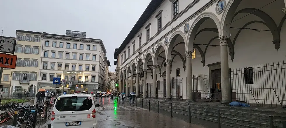 The arched Renaissance loggia on Piazza della Santissima Annunziata on a rainy day in Florence