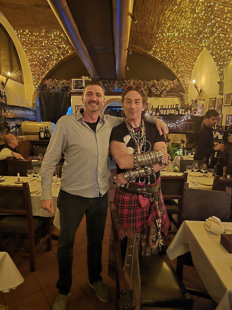 Jason GaNung and Soldano standing between candlelit tables in the arched dining room at La Giostra Florence