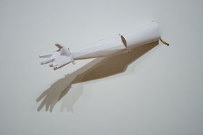 14 mechanical paper arms are mounted on a wall, swaying back and forth in a synchronised movement