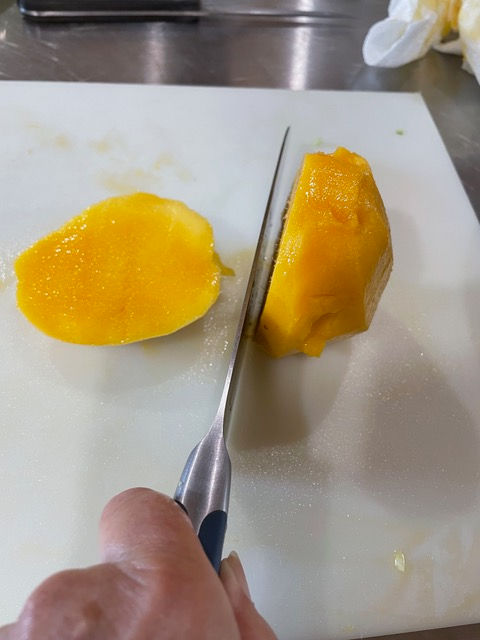 Slice away the mango flesh from the elliptical pit, from top to bottom.