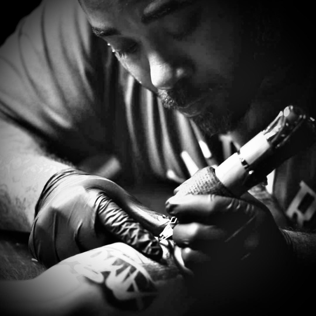 Tazz the tattoo artist, precisely inking someone with a tattoo needle.