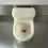 Thumbnail: Mini White toilet with Red middle finger inside, tilted front view on metal surface