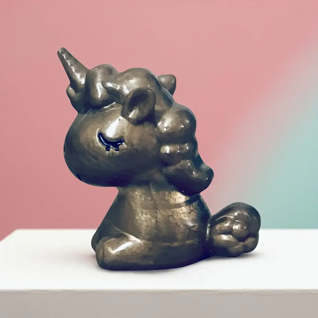 Gold Baby Unicorn Statue Left Side View On A Shelf, With Pink Wall