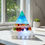 Thumbnail: Bespoke Large Resin Pyramid Lamp illuminated with colorful lights, near window and plant.