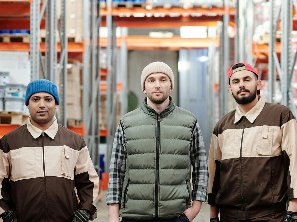 Three warehouse workers looking directly at the camera.