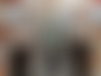 Three warehouse workers standing in the warehouse corridor looking directly into the camera.