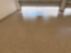 High-gloss solid tan epoxy floor coating showing a flawless protective finish in a garage.