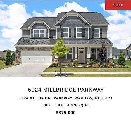 Luxury two-story house with large windows, columns, and a well-kept lawn and driveway.
