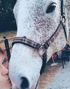 Riding instructor kissing lesson horse on the nose