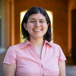 Dr. Acosta smiling in front of a college building