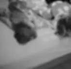 mom and toddler laying on bed looking at eachother